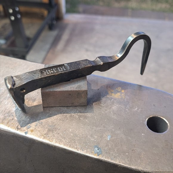 Blacksmith tool on a metal surface with blurred background