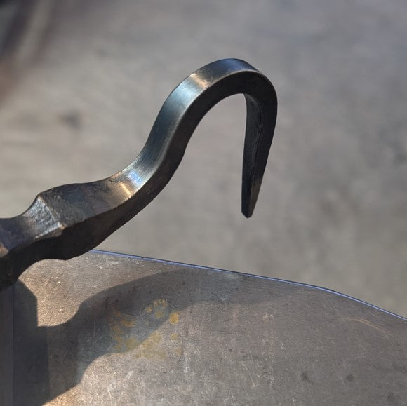 Metal hook on a gray surface