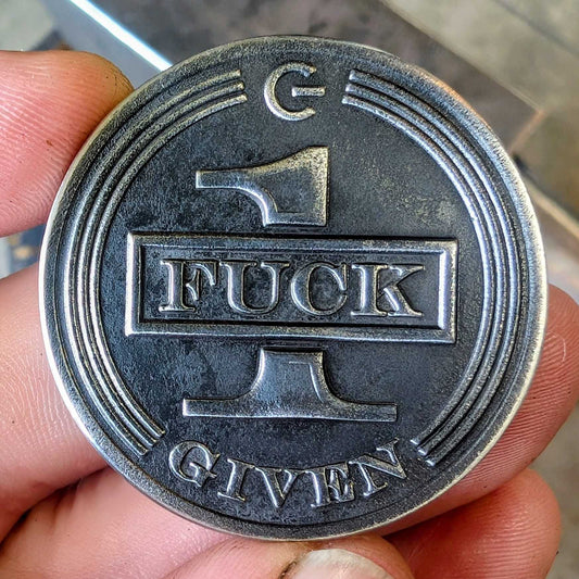 A stainless steel coin that says one fuck given.