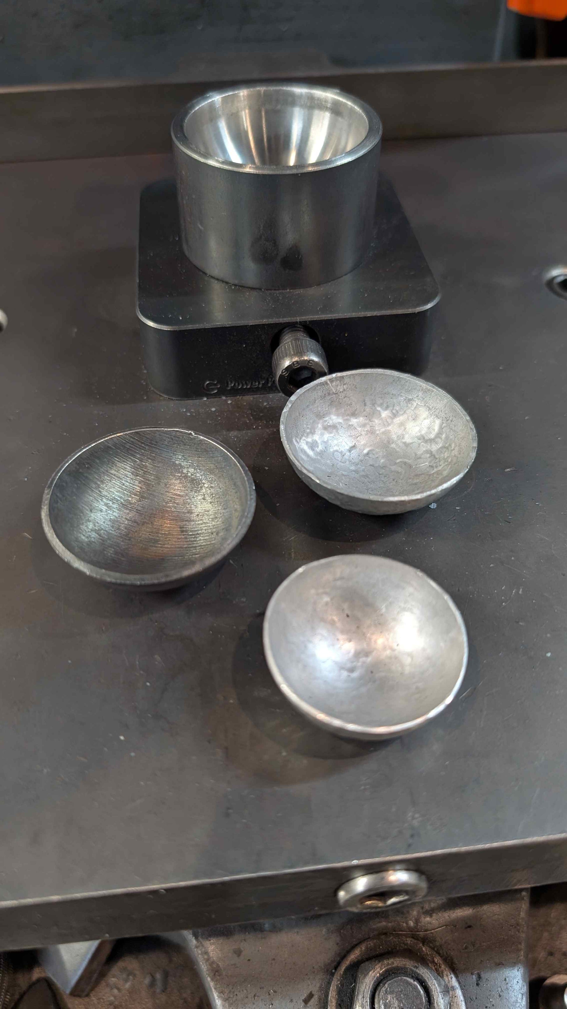 Bottom forming die with three formed coffee spoons.