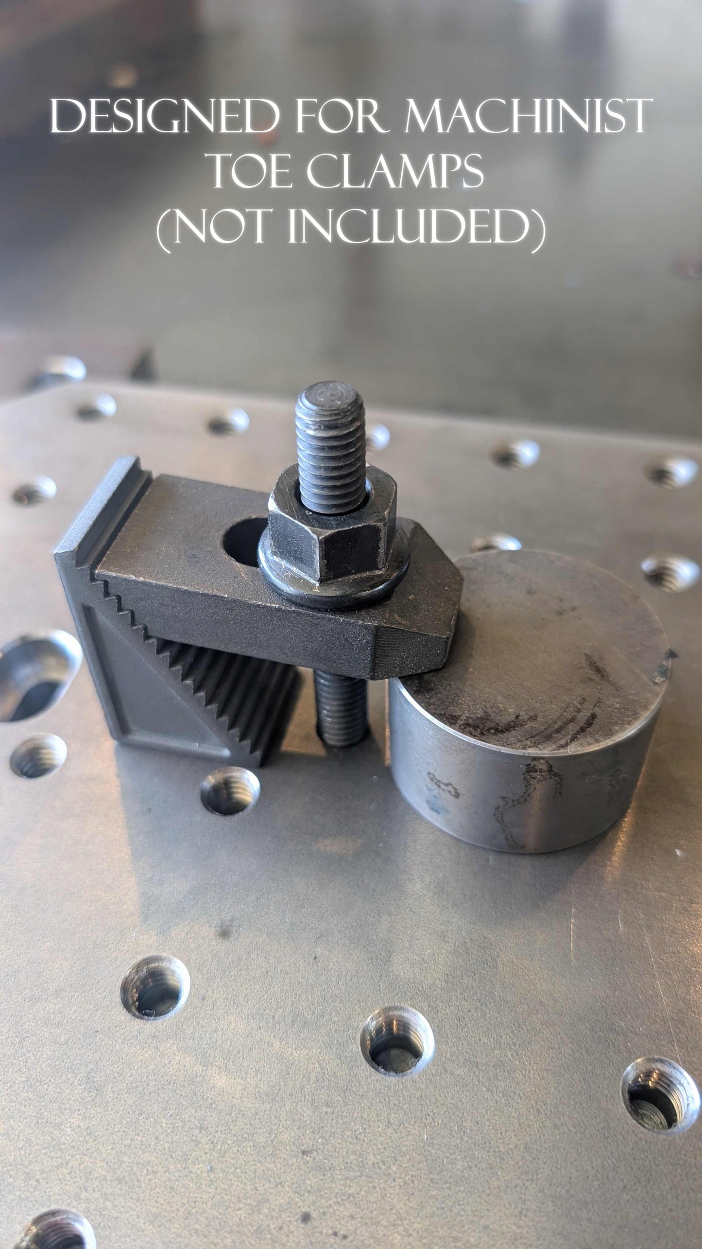 Metal clamping device on a metallic surface with text indicating it is designed for machinist Toe Clamps.