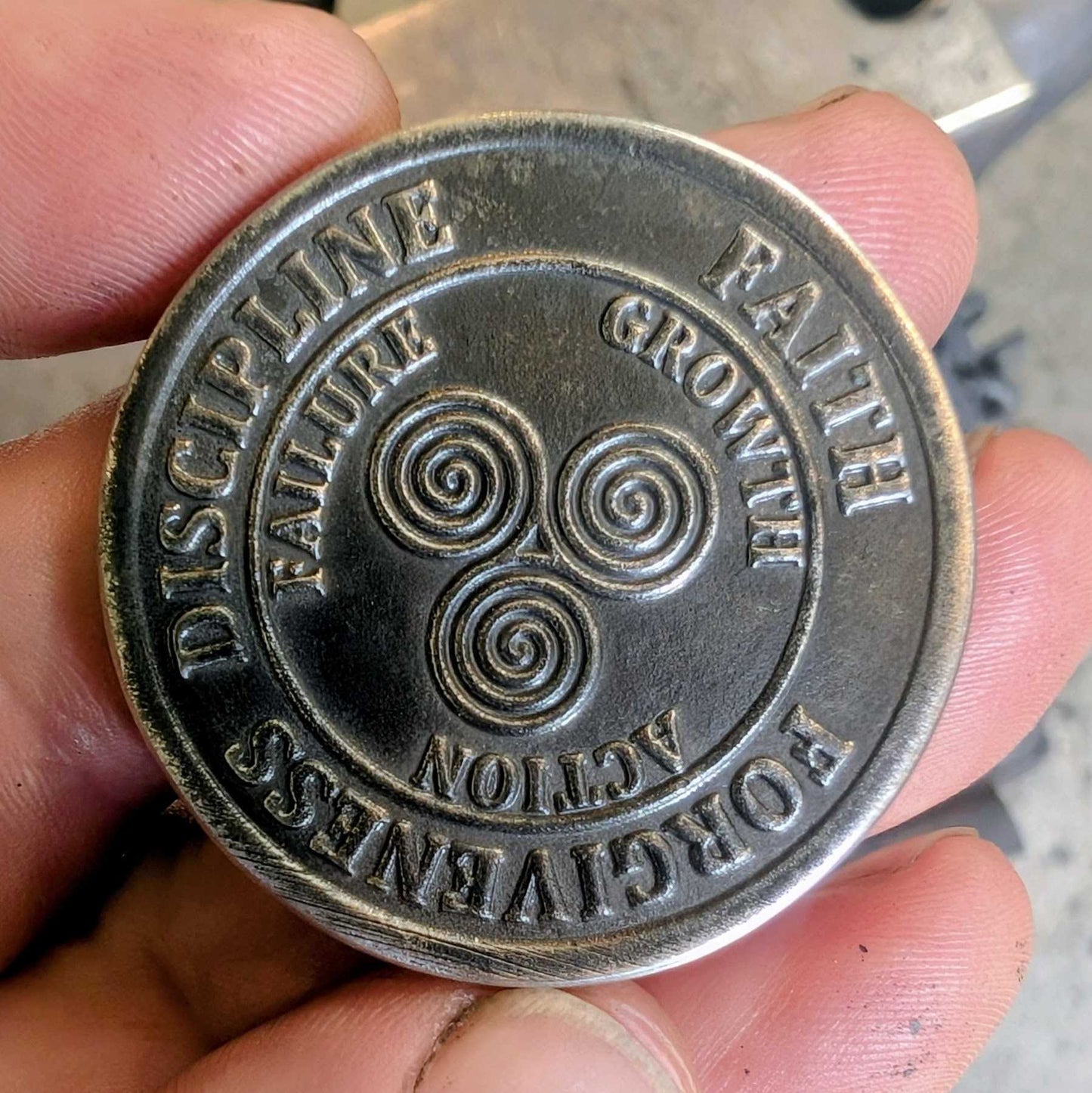 Inspirational coin with the words Discipline, Faith and Forgiveness. 