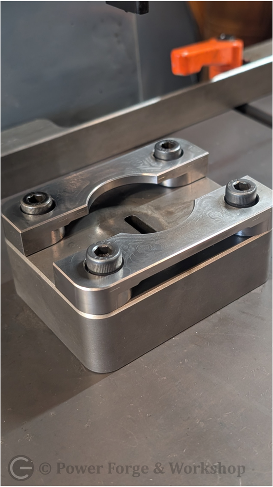 Metal component on a machine with 'Power Forge & Workshop' branding