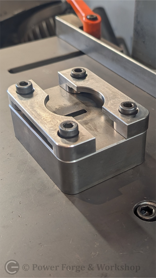 Metal component with bolts on a workshop surface, branded 'Power Forge & Workshop'.