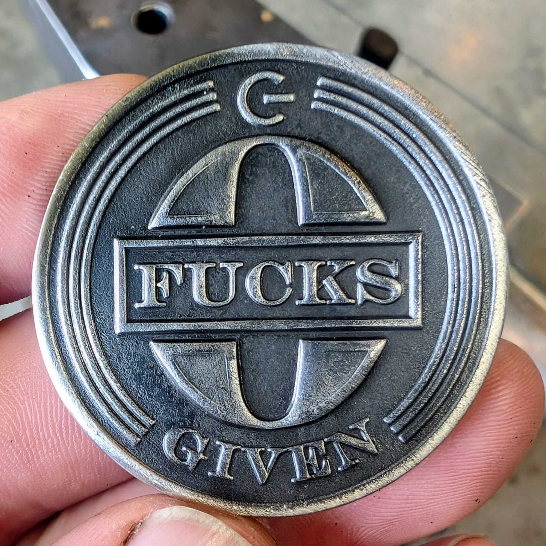 A stainless steel coin that says zero fucks given. 